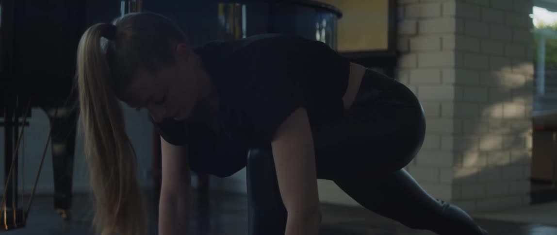 A woman is stretching and doing yoga indoors