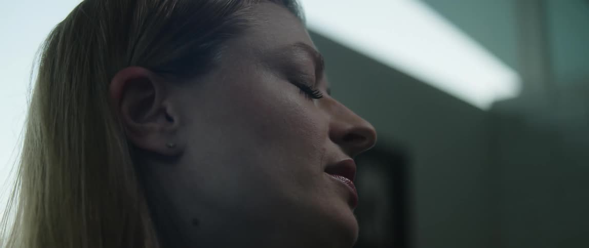 A close up of a womans face singing while her eyes are closed