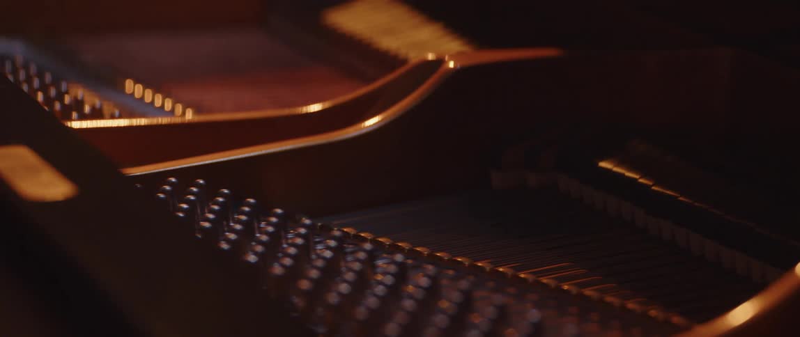 Close up of grand piano strings being played