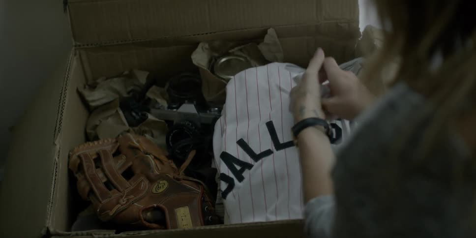 A person opens a box of baseball uniforms