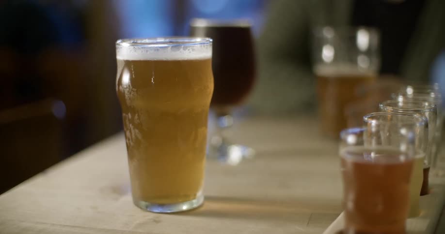 Beers sitting on a counter and someone sitting at the end of the counter