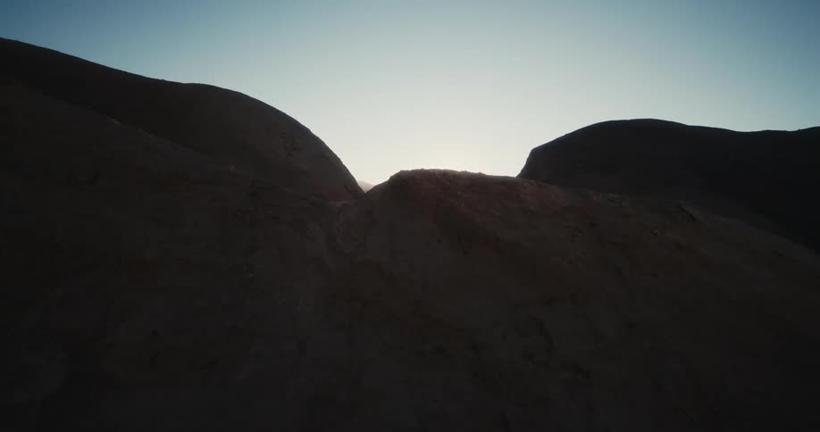 Sunlight shining over dirt covered hills and mountains in nature