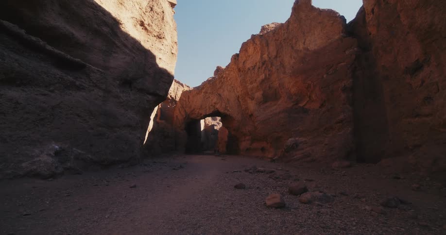 Walking on a canyon in the desert surrounded by rock cliffs at morning