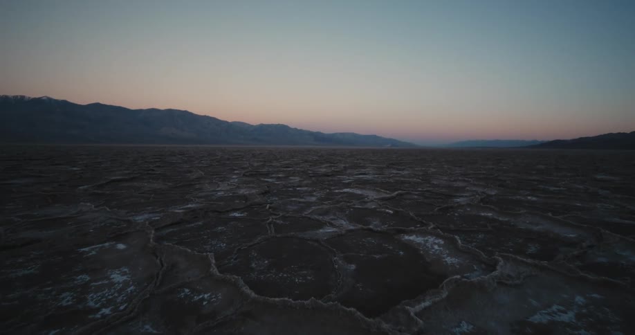 Barren plains in the tundra near close to a mountain range in the horizon at evening