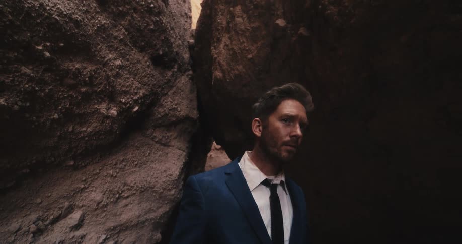 A man walks slowly through a canyon