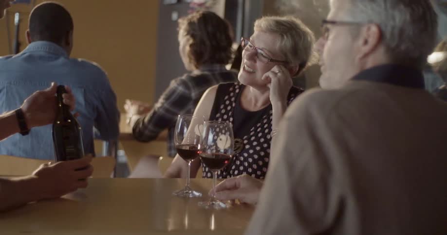 People sitting at a table with wine and talking