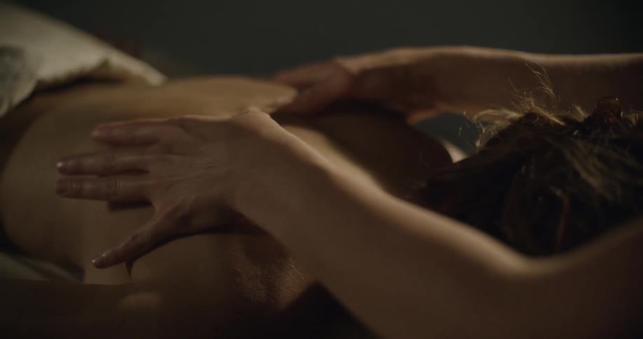 A woman's hands as she massages a man's back