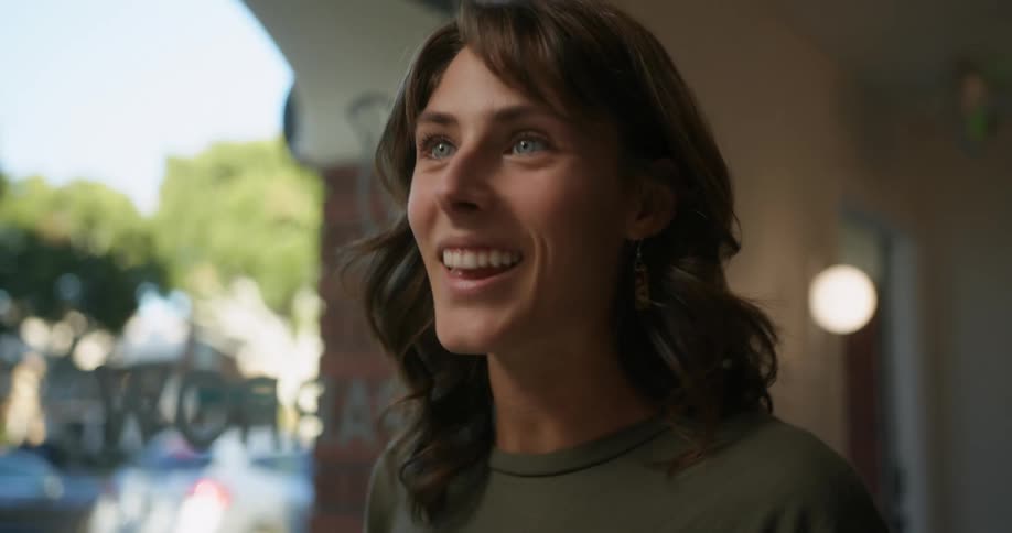 Smiling woman nervously ordering food from menu at a counter