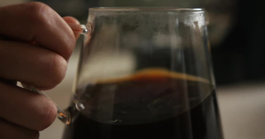 Close up of coffee being swirled in a glass mug