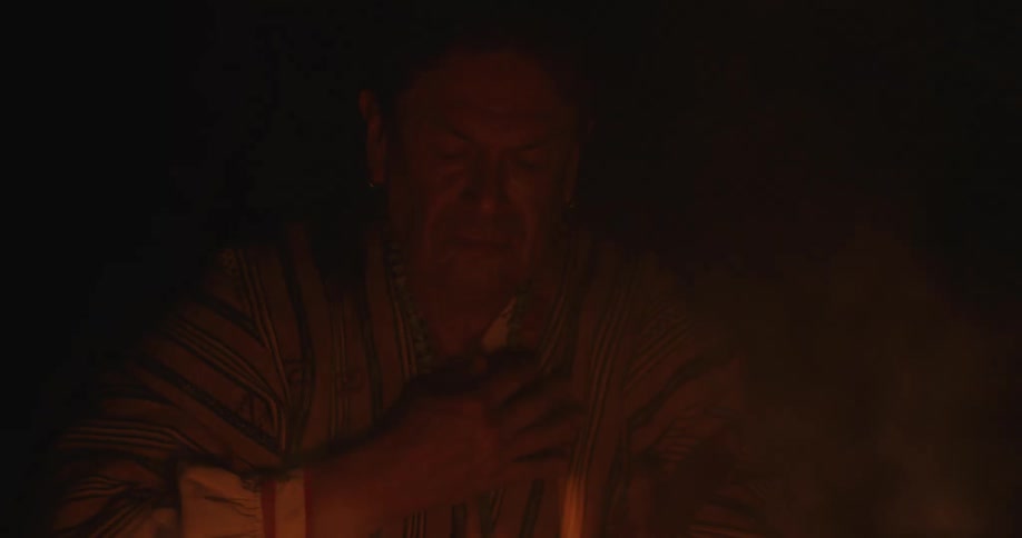 A man sitting outside next to a fire