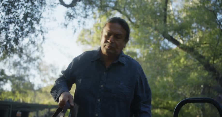 A man is outdoors and moving a bag