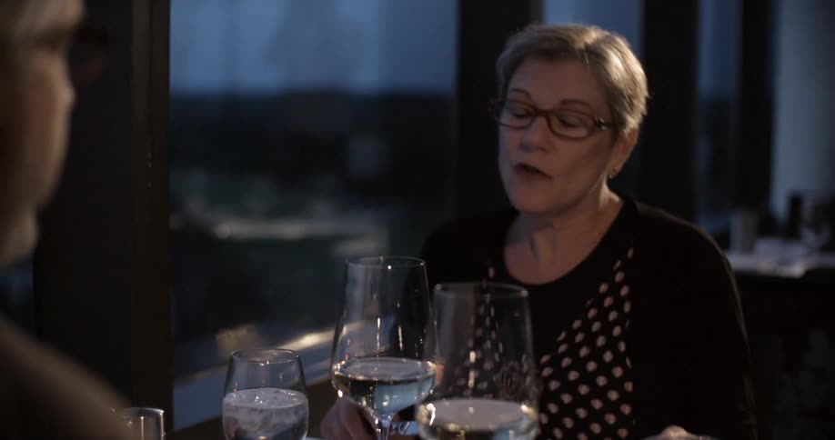 People are sitting down to a meal talking