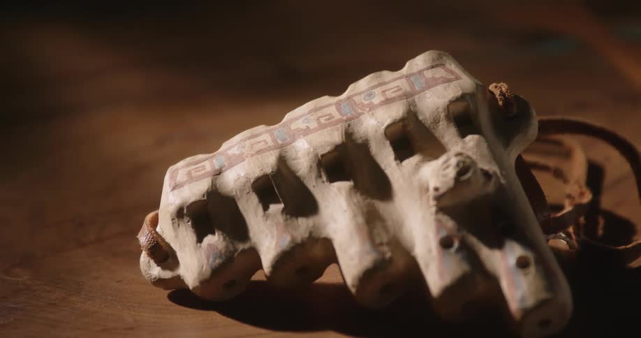 Close up of a bone like made amulet over a wooden table