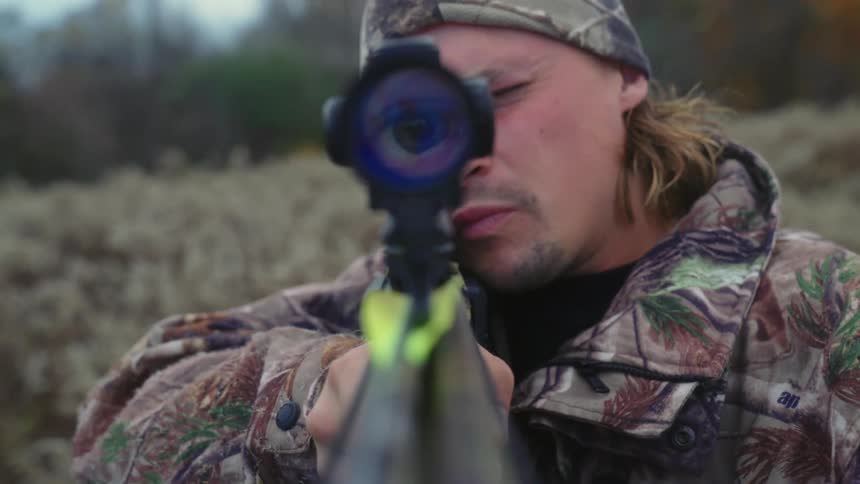 A man looking through a gun scope