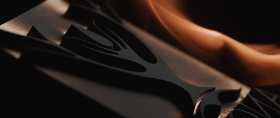 A flame burning next to a black object