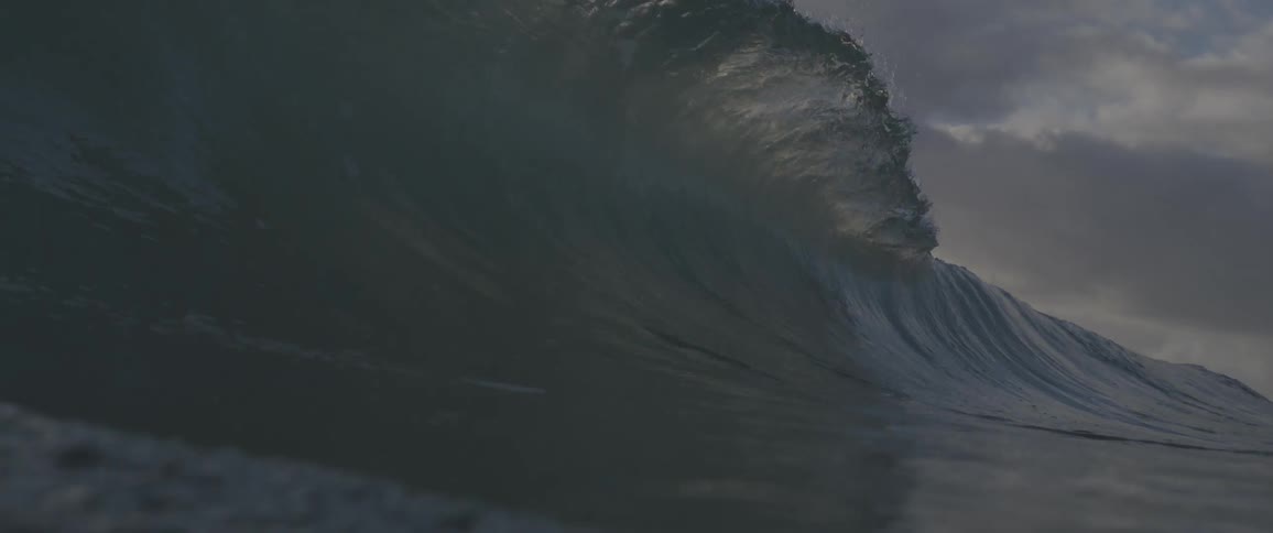 The large wave crashes in the ocean