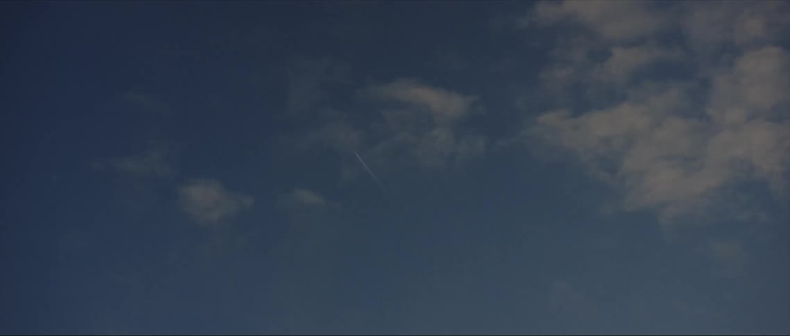 Soft clouds are scattered across a blue sky