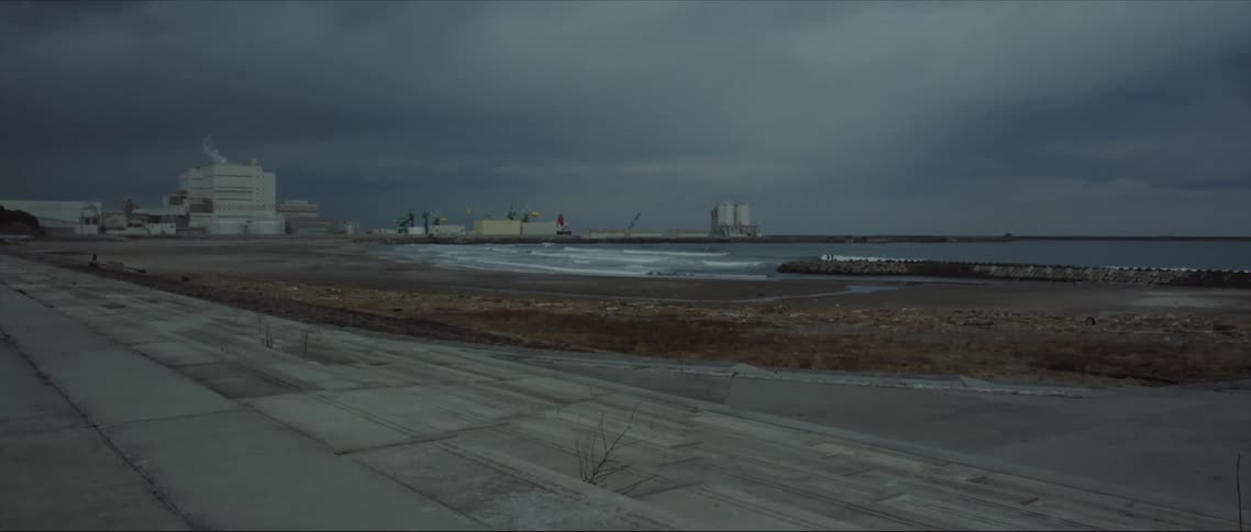 A factory near a river with barges nearby
