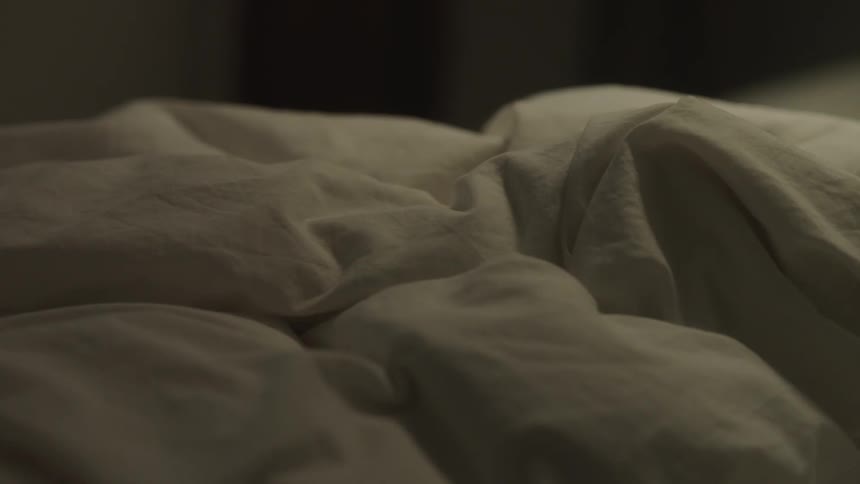 Rumpled bed linens remain piled together