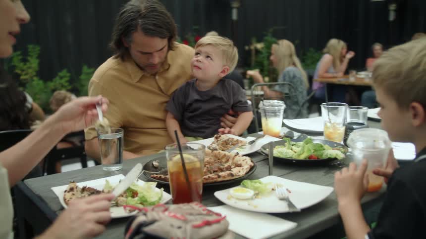 Families eat meal in restaurantfloored with fake grass