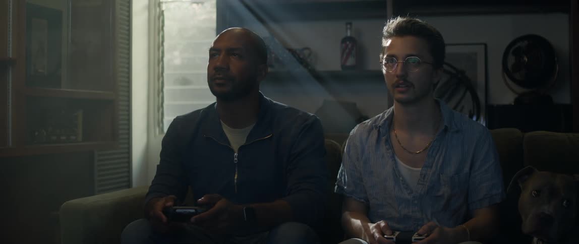 Two men sit playing video games together