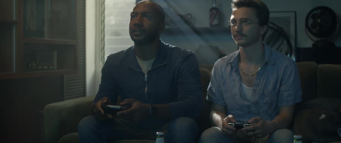 Two men play video games and talk