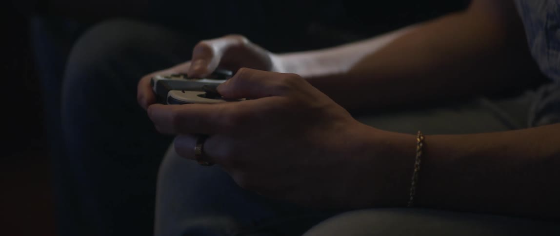 Two men sitting on couch use video game controller