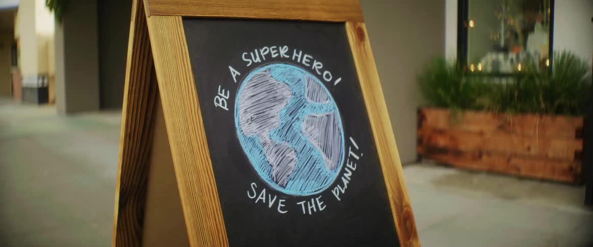 A signboard outside of a business that reads save the planet