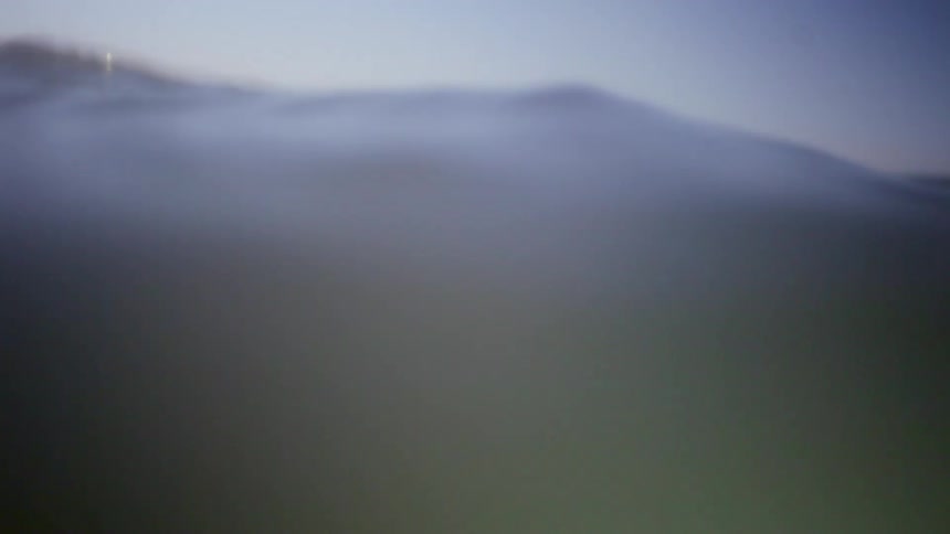 A woman swims in murky water