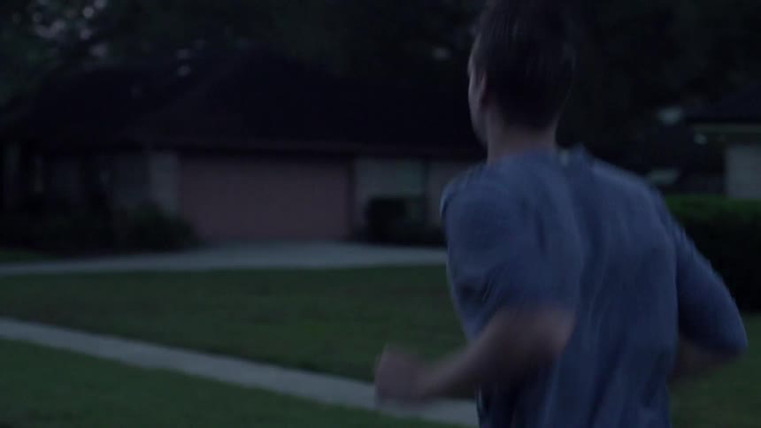 A man jogs down the road in a subdivision