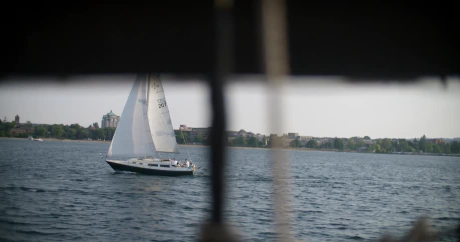 Boats sail in the water on a cloudy day