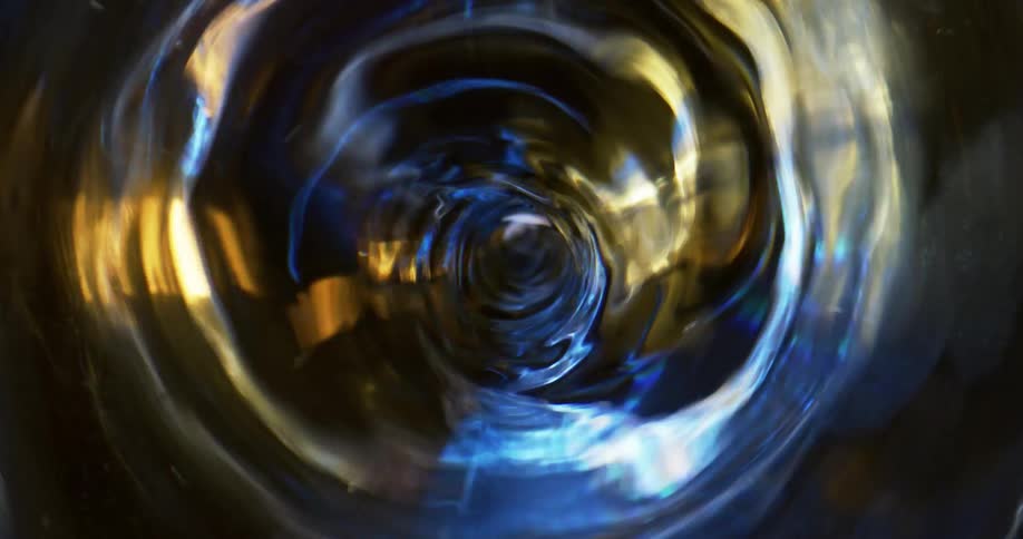 Top down close p of the interior of a blender spinning a swirl of clear liquid
