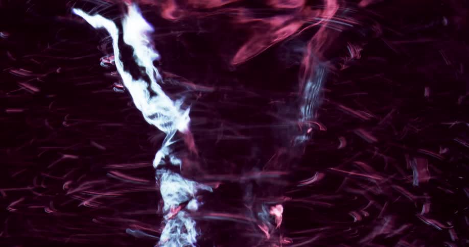 Particles move around a swirling tornado as it rapidly moves in the darkness