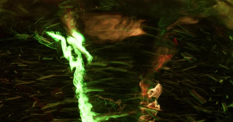 Particles are swirling around a liquid vortex as light reflects on the surface as it spins