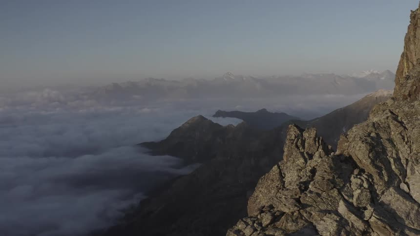 Low lying clouds fill area between craggy mountains