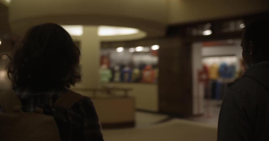 Two people walk down a hall together