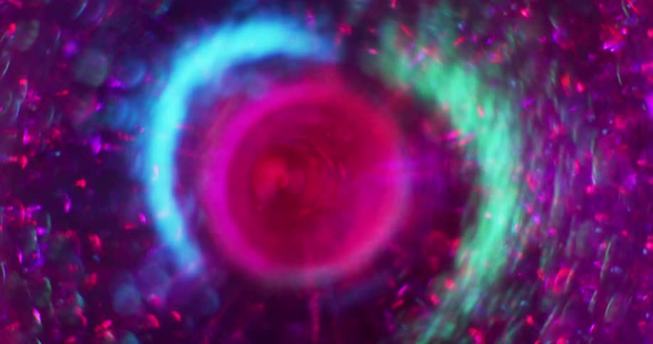 Pink particles move around a swirling magenta vortex and neon green and blue light shines as it spins