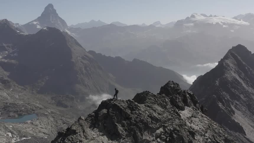 A hiker is perched on the mountain top
