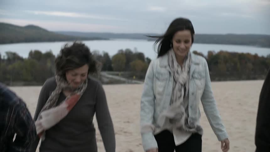 A group of people walk in the sand