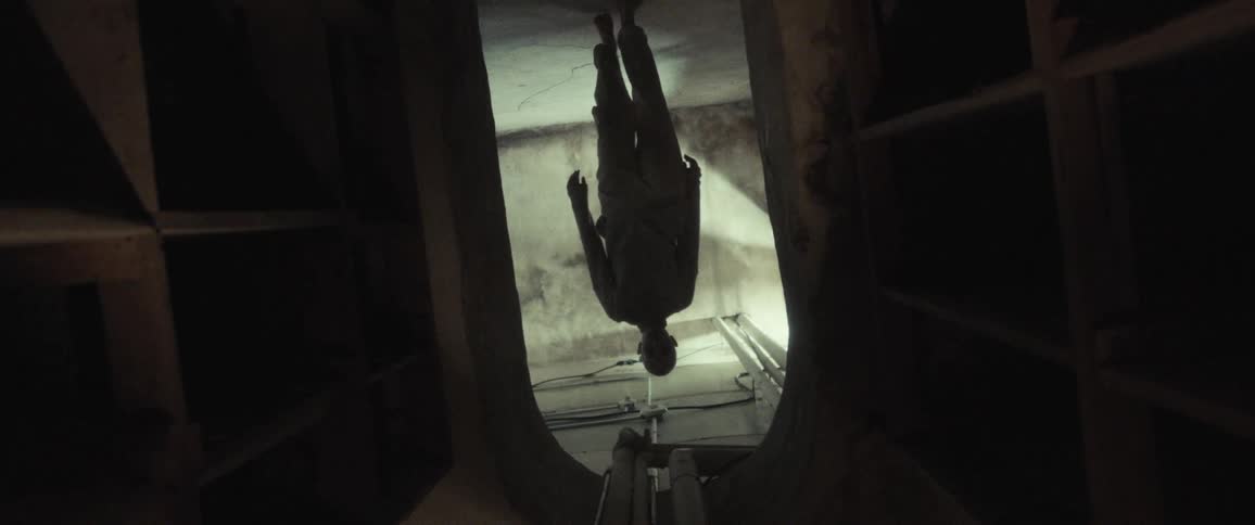 A person is walking in the dark basement