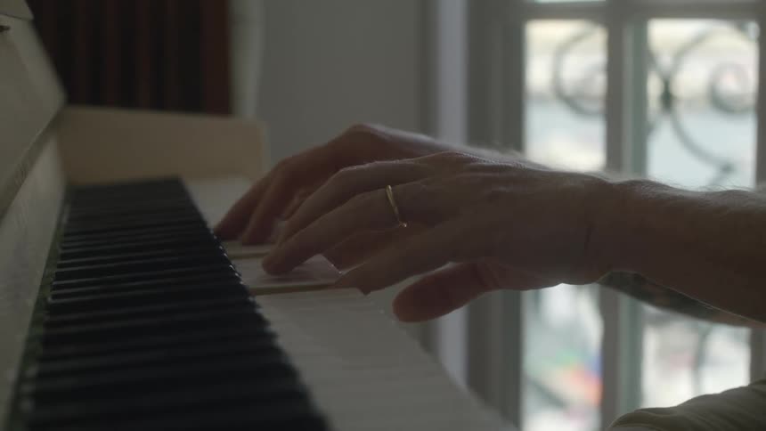 Close up view of a person playing the piano indoors