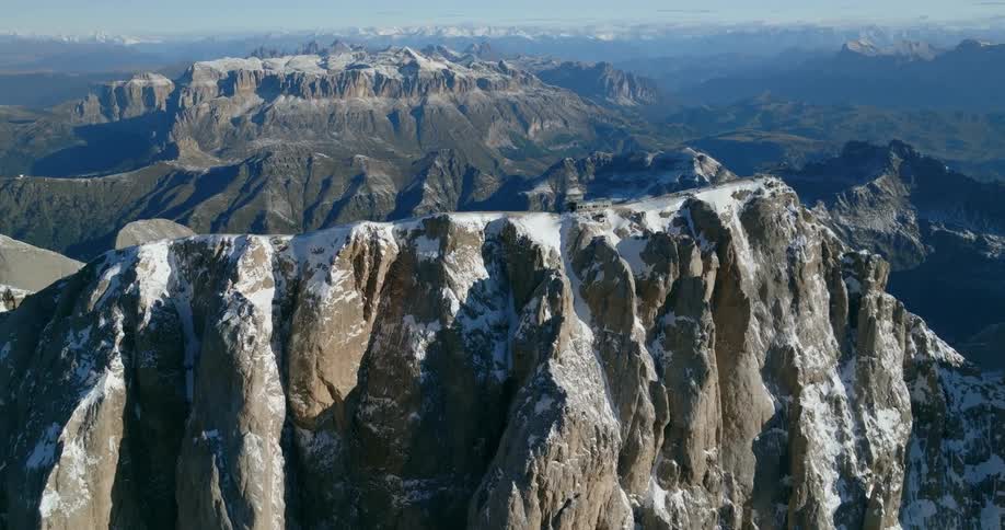 Snow covers mountain as other mountains in range stretch to the horizon under a covering of fog