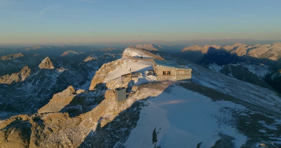 A small building sits on top of a mountain