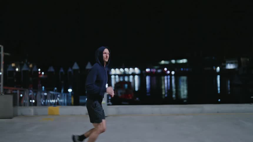 Man jogs along waterfront at night