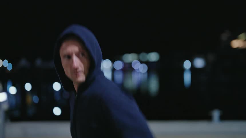 A man runs alongside a river at night