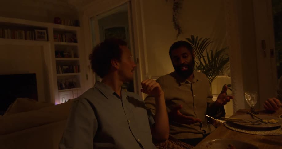 Friends sit at dinner table conversing