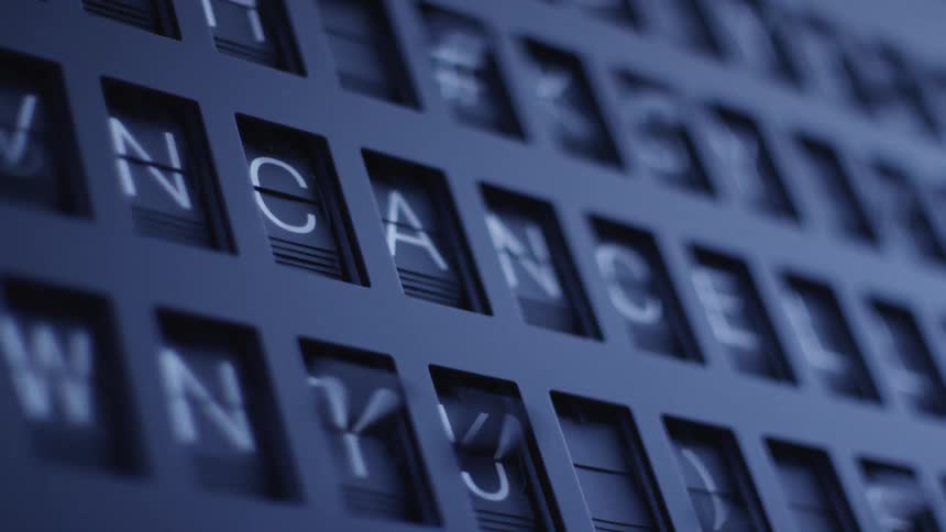 The letters numbers and symbols on a departure board flip leaving only the word cancelled