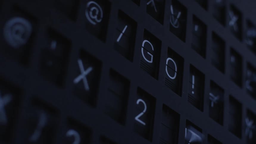 Spinning characters on an airport flight schedule billboard forming words