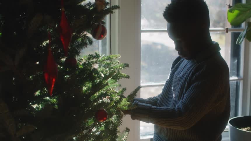 A child is decorating a christmas tree