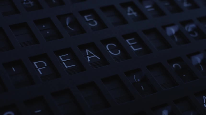 Text and symbols flash across a sign until it spells out the word peace